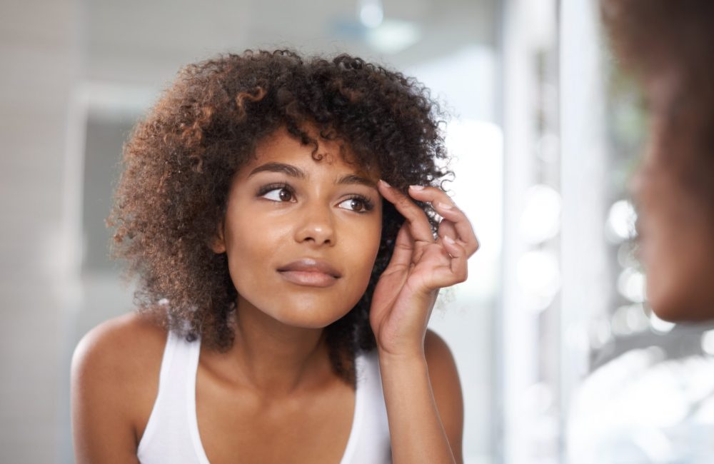young woman checking her beautiful face on the mirror